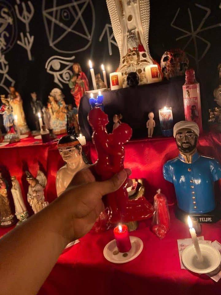 Altar con velas rojas y pétalos